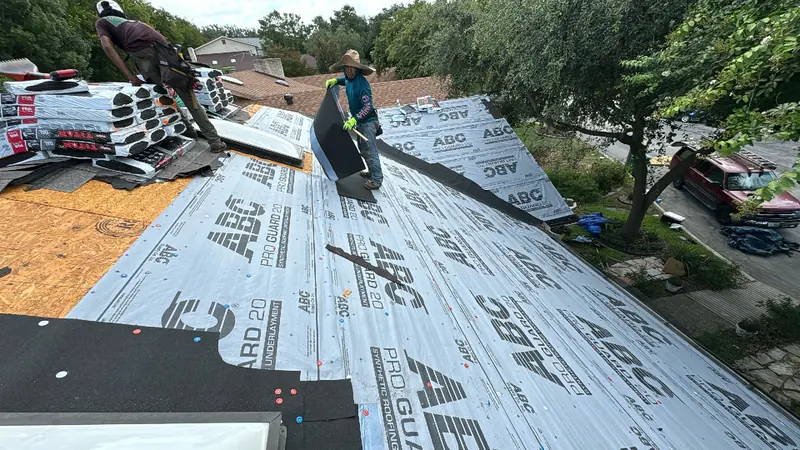 HWT crew tearing off old shingles and rolling out synthetic underlayment