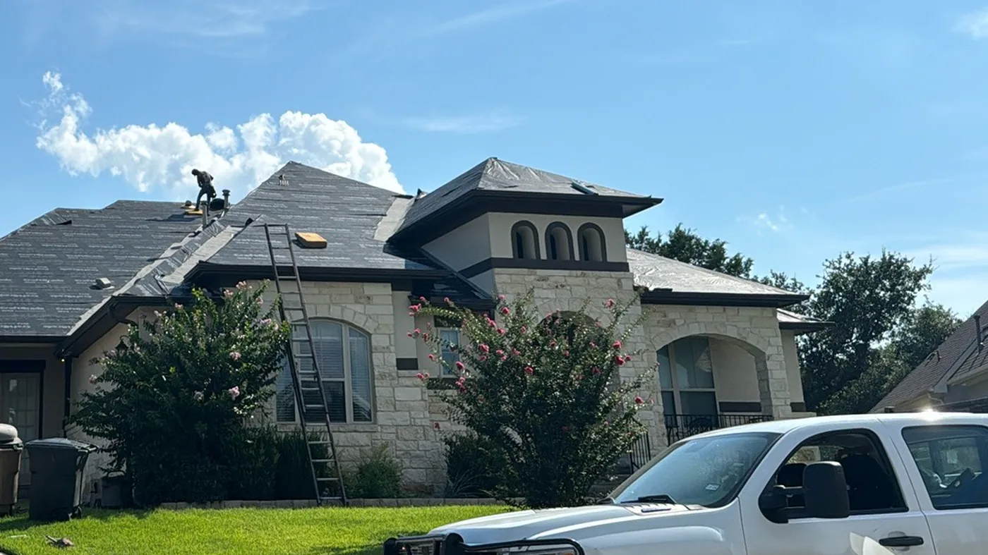 Central Texas home mid roof replacement — HWT crew tearing off the old shingles
