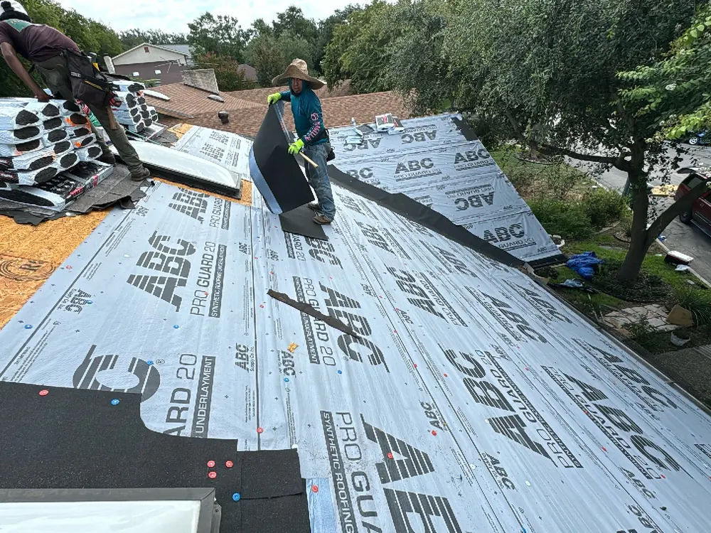 HWT Construction crew tearing off old shingles down to the decking on a Central Texas home